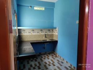 a small bathroom with a sink and a blue wall at Harmony Waves Homestay in Havelock Island