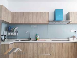 a kitchen with wooden cabinets and a sink at Marina Times Square Homestay by Evernent in Miri