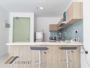 a kitchen with a counter and two bar stools at Marina Times Square Homestay by Evernent in Miri