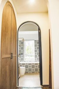 an archway leading into a bathroom with a toilet and a window at Seamoni Seaview Villa 01 - Novaworld Phan Thiết in Phan Thiet