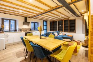cocina y comedor con mesa de madera y sillas amarillas en Le Cocon Enneigé - Duplex 3 chambres, en Formiguères