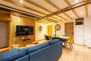 sala de estar con sofá azul y mesa en Le Cocon Enneigé - Duplex 3 chambres, en Formiguères