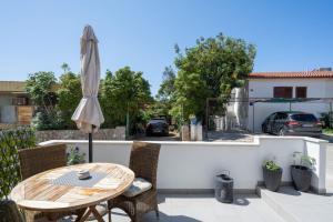 eine Terrasse mit einem Tisch und einem Sonnenschirm in der Unterkunft Apartments K & N in Prizba