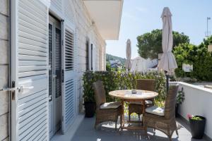 eine Terrasse mit einem Tisch, Stühlen und einem Sonnenschirm in der Unterkunft Apartments K & N in Prizba