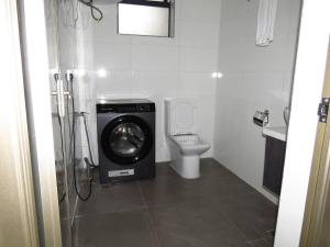 een badkamer met een wasmachine en een toilet bij Spacious 3 Bed Apartment-Gym Pool and Rooftop View in Nairobi