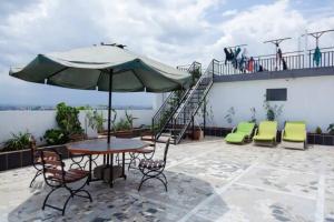 een patio met een tafel en stoelen en een parasol bij Spacious 3 Bed Apartment-Gym Pool and Rooftop View in Nairobi
