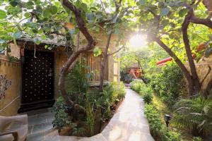 einen Garten mit einem Gehweg mit Bäumen und Pflanzen in der Unterkunft Nature Village Resort in Pushkar