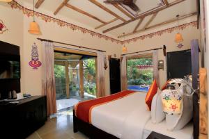 a bedroom with a bed and a large window at Nature Village Resort in Pushkar