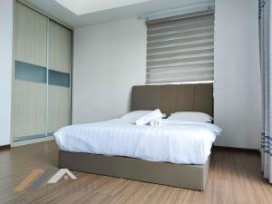 a bedroom with a large bed with white sheets at Serene Heights by Evernent in Miri