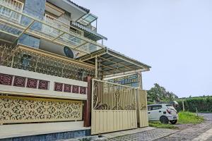 a house with a gate and a fence at OYO 91707 Jannah Homestay Syariah in Dau