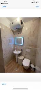een badkamer met een wit toilet en een wastafel bij Properhome Saranda in Sarandë