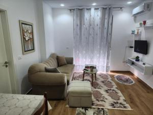 een woonkamer met een bank en een tafel bij Properhome Saranda in Sarandë