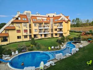 a large building with a swimming pool in front of it at Apartment Oasis A4 Kamchia in Bliznatsi