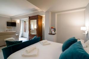 a bedroom with a white bed and blue chairs at Al Duomo Rooms & Flats in Taormina