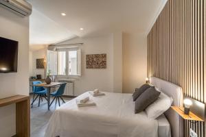 een slaapkamer met een groot wit bed en een tafel bij Al Duomo Rooms & Flats in Taormina