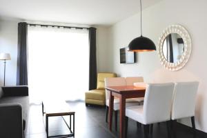 a dining room with a table and white chairs at Holiday Resort Van der Valk, Linstow in Linstow