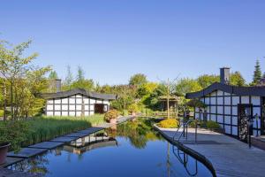 a garden with a pond and two buildings at Holiday Resort Van der Valk, Linstow in Linstow