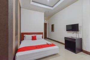Schlafzimmer mit einem Bett und einem Flachbild-TV in der Unterkunft RedDoorz near Universitas Maranatha Bandung in Bandung