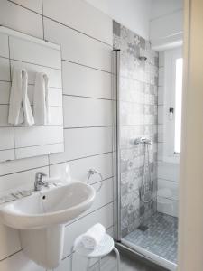 a white bathroom with a sink and a shower at Hotel Goya in Crevillente