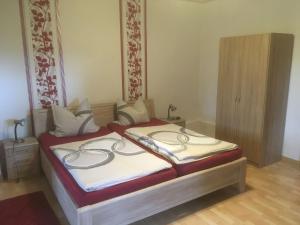 een slaapkamer met een bed met witte en rode lakens bij Two separate farmhouse apartments under one roof in Trendelburg