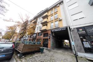 a building with a car parked in front of it at Lux Place Apartments Downtown in Kragujevac