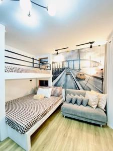 um quarto com 2 beliches e um sofá em Antara-QueenBed-Balcony-HotShower-WorkCoffee Station-FullKitchen em Talisay