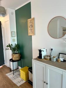 a kitchen with a green wall and a mirror at Studio Dolce Vita Aix en Provence in Aix-en-Provence