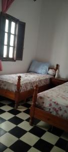 a bedroom with two beds and a window at My house in Rabat