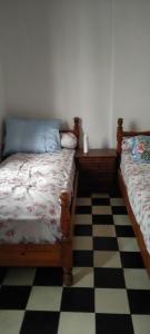 a bedroom with two beds and a checkered floor at My house in Rabat