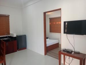 a living room with a television and a mirror at Villa Marilyn Resort and Hotel in Coron