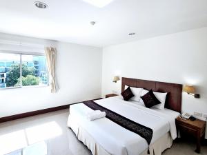 um quarto com uma cama grande e uma janela em Nanthana Villa em North Pattaya