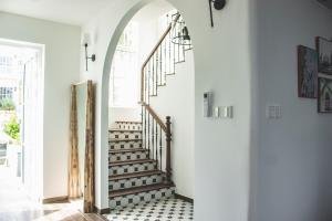 a hallway with a spiral staircase in a home with white walls at Seamoni Seaview Villa 02 - Novaworld Phan Thiết in Phan Thiet