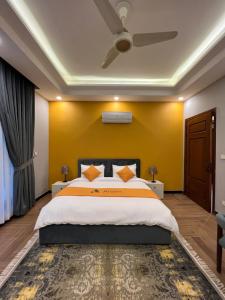 a bedroom with a large bed with a yellow wall at The SoHo in Islamabad