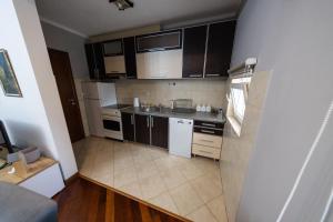 a small kitchen with white appliances and brown cabinets at Lux Place Apartments Downtown in Kragujevac