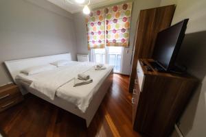 a bedroom with a bed and a flat screen tv at Lux Place Apartments Downtown in Kragujevac