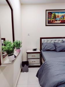 a bedroom with a bed and two potted plants at SR Apartments Islamabad in Islamabad