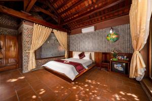a bedroom with a bed in a room with wooden ceilings at Tam Coc Ngoc Linh Bungalow Ninh Bình in Ninh Binh