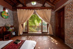 a bedroom with a bed and a large window at Tam Coc Ngoc Linh Bungalow Ninh Bình in Ninh Binh +24 photos