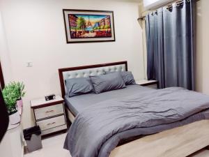 a bedroom with a bed and a picture on the wall at SR Apartments Islamabad in Islamabad