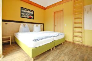 a bedroom with a large white bed with yellow walls at Wohnung in Plau am See in Plau am See