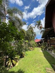 un jardín frente a una casa con palmeras en ครูหนูบ้านพัก แหลมงอบ Krunou baanpak en Trat