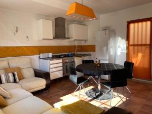 Una cocina y una sala de estar con una mesa y un sofá. en Mirador de Sierra Nevada, en Güéjar-Sierra