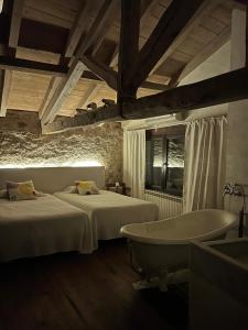 1 dormitorio con 2 camas y bañera en Casa Rural La Chocolateria, en Horche