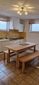 una cucina con tavolo in legno e 2 panche di Ferienhaus Weilheim mit Garten Spiel und Spass a Weilheim in Oberbayern