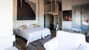 1 dormitorio con 1 cama y 2 sillas blancas en Casa Rural La Chocolateria en Horche