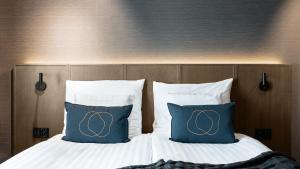 two pillows with olympics on them on a bed at Original Sokos Hotel Puijonsarvi in Kuopio