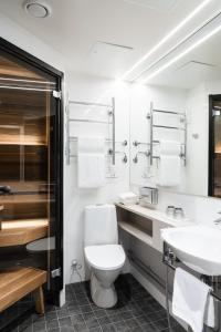 a white bathroom with a toilet and a sink at Original Sokos Hotel Puijonsarvi in Kuopio