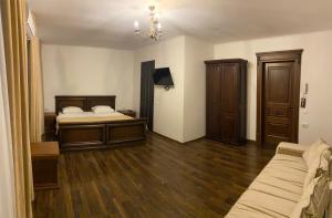 a bedroom with a bed and wooden floors and a chandelier at Едем in Brzezhany