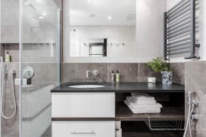 a bathroom with a sink and a shower at Apartamenty Premium - kompleks Deo Plaza in Gdańsk