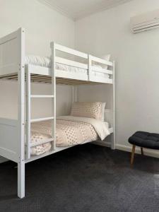 Luxury stay in Williamstown في ويليامزتاون: سرير أبيض بطابقين في غرفة بيضاء
